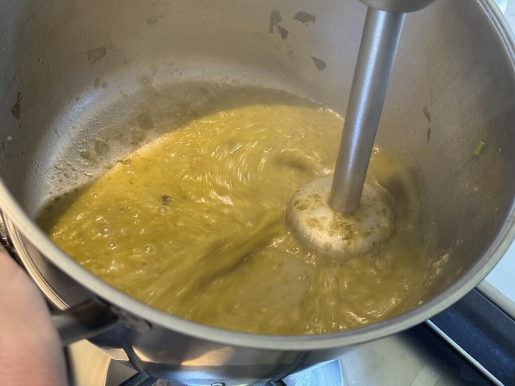 immersion blender in pot with blended sorrel soup