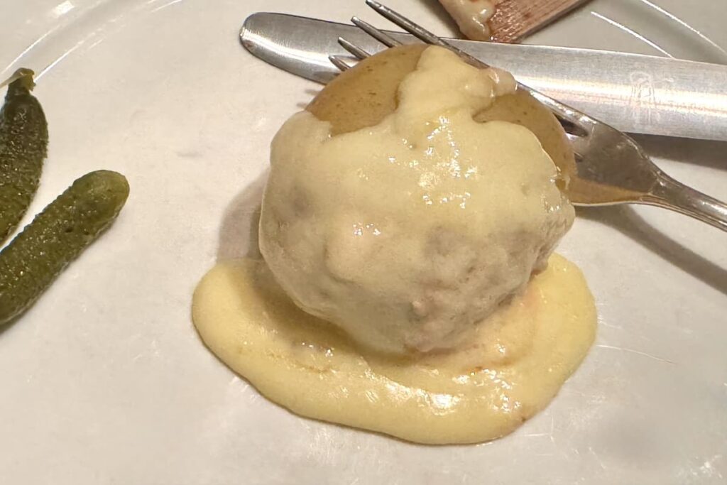 melted raclette cheese over boiled potato on plate