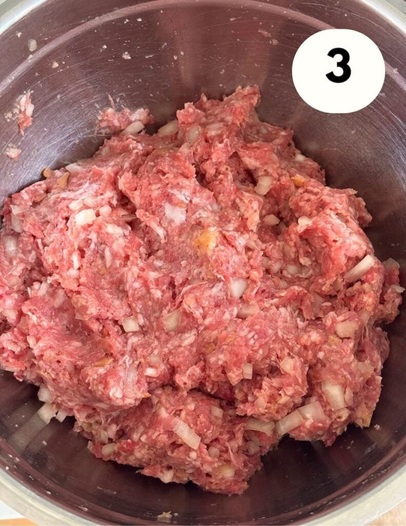 Uncooked frikadellen hamburger mixture in a mixing bowl.