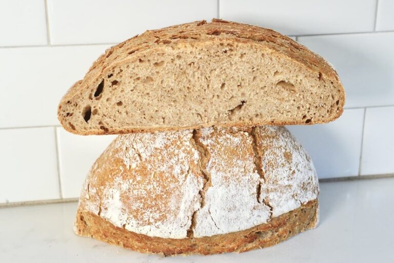 loaf of homemade bread cut in half on kitchen counter