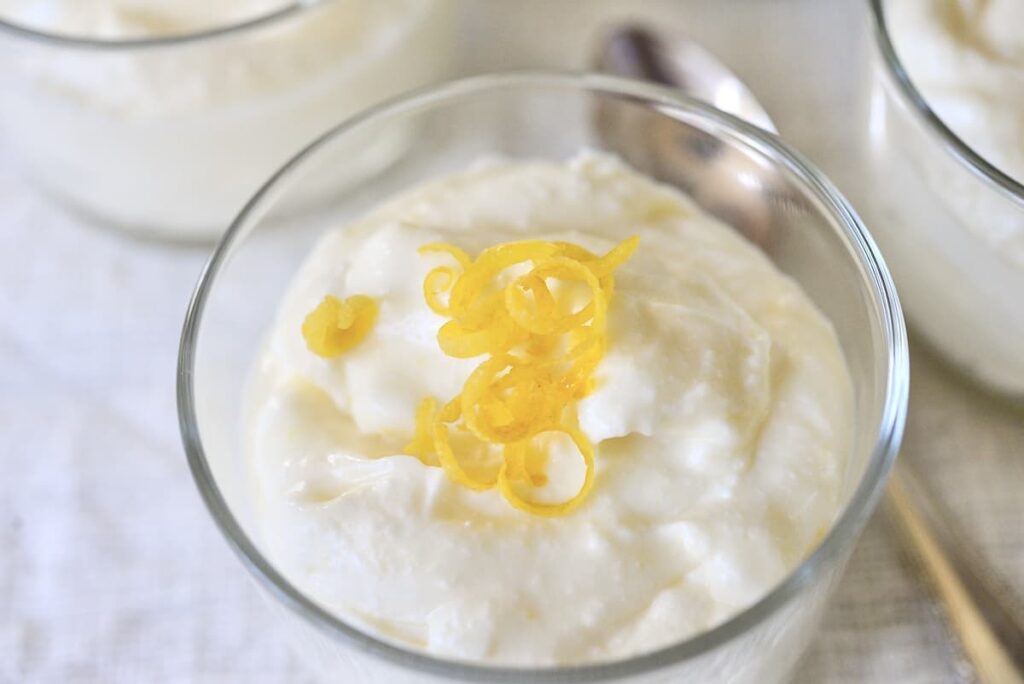 lemon mousse in bowl with strips of lemon zest on top