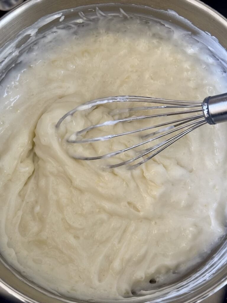 wire whisk whisking yogurt into lemon base
