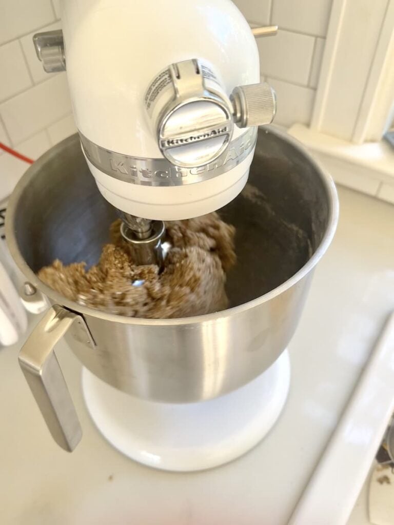 Mixing pumpernickel bread dough in the bowl of a KitchenAid stand mixer.