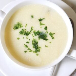 bowl of white asparagus soup garnished with parsley