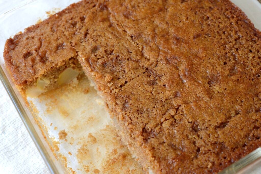 apple cake in baking dish with 3 pieces already eaten