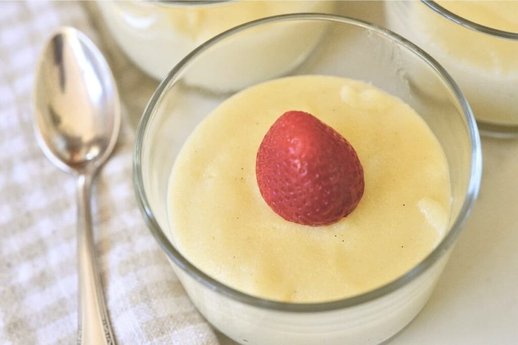 small glass bowl with German Griessbrei topped with strawberry