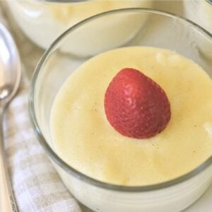 small glass bowl with German Griessbrei topped with strawberry
