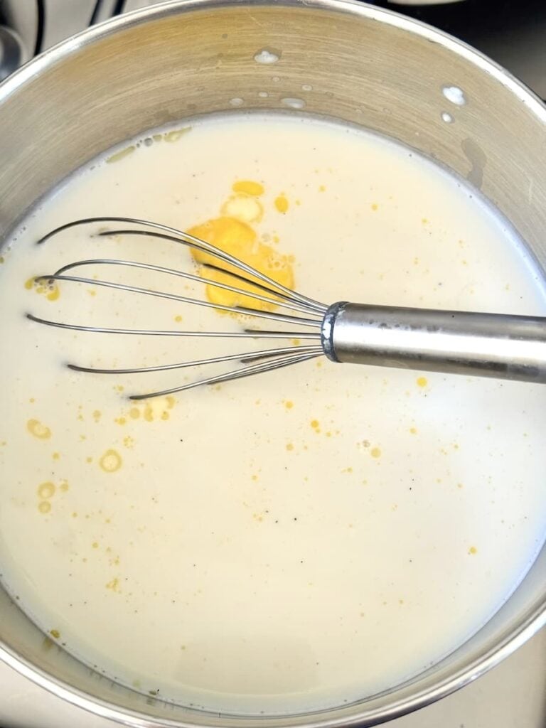 milk and butter in saucepan with wire whisl