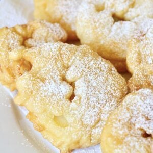 Apfelküchle dusted with powdered sugar on plate