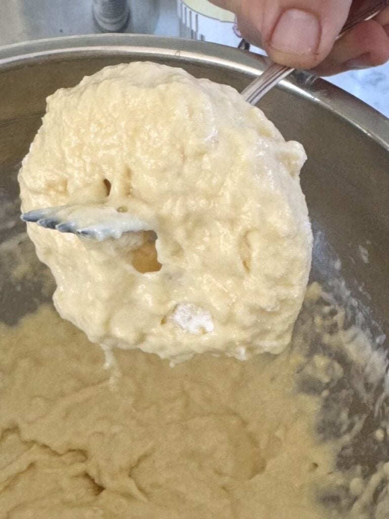 apple ring coated in batter over bowl
