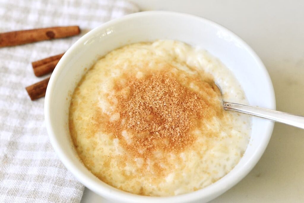 bowl with German rice pudding sprinkled with sugar and cinnamon powder