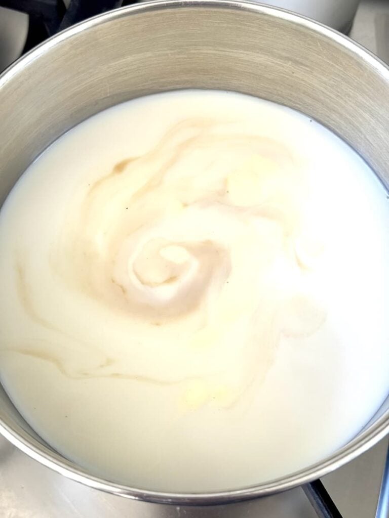 saucepan on stovetop with milk and other ingredients