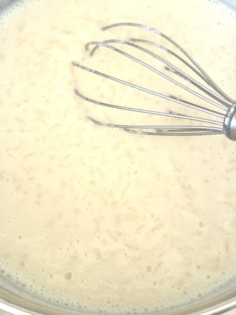 German rice pudding in saucepan on stovetop with wire whisk