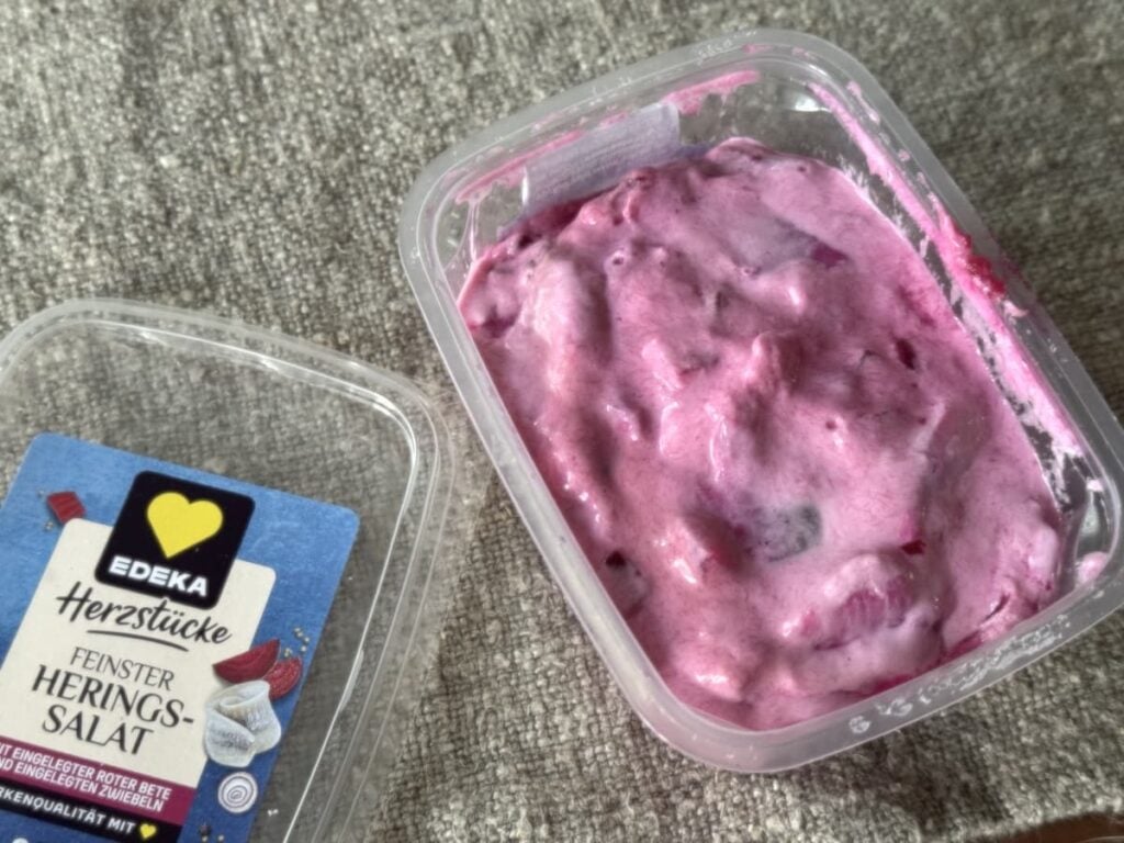 German pickled herring salad in container on table