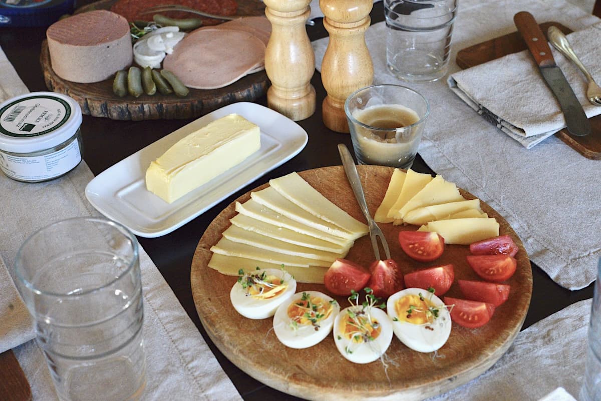 supper table set with cheese board, butter, and cold cuts