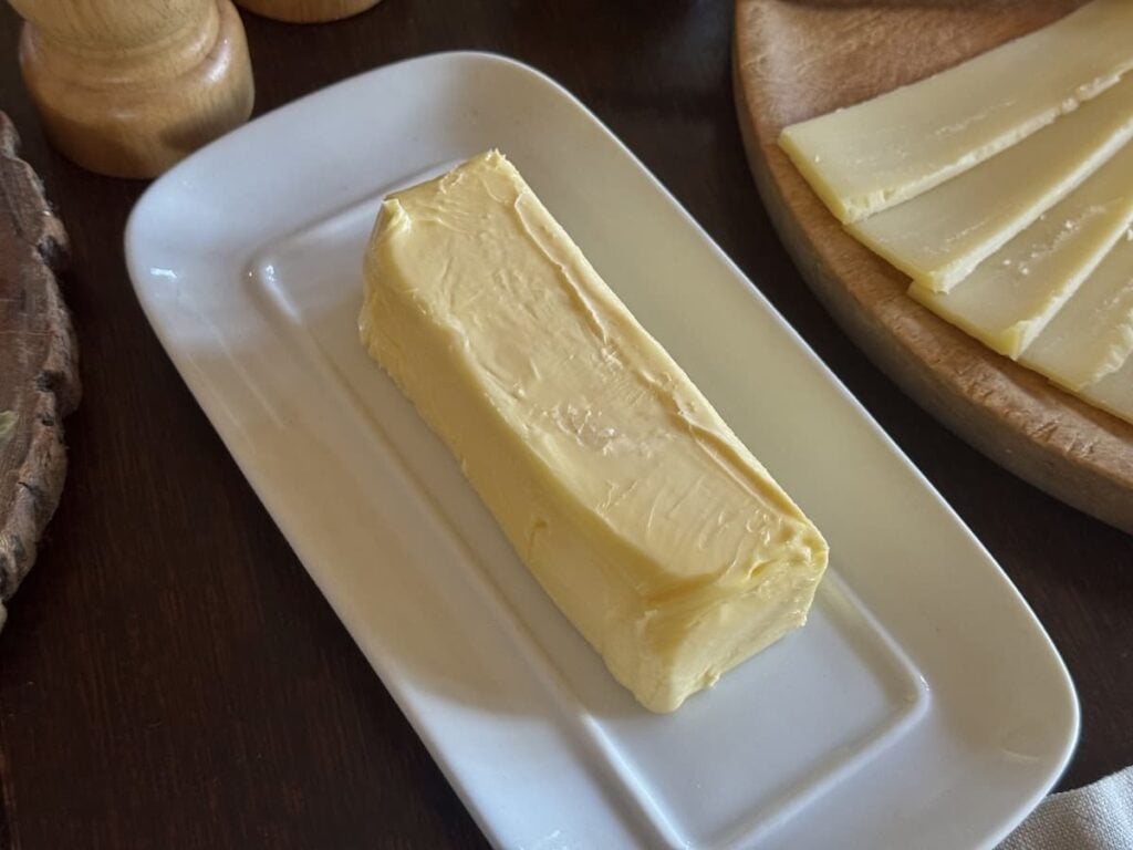 porcelain butter dish with stick of butter on table