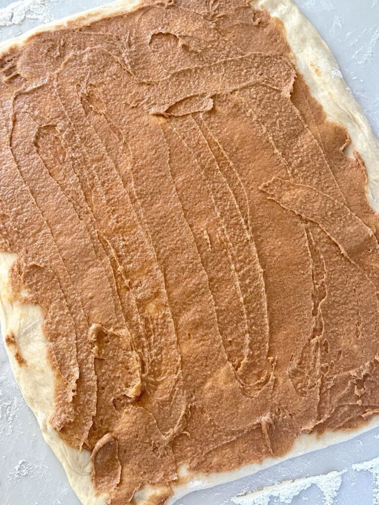cinnamon filling spread on dough rectangle