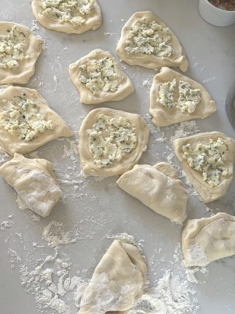 dough pieces topped with filling on kitchen counter