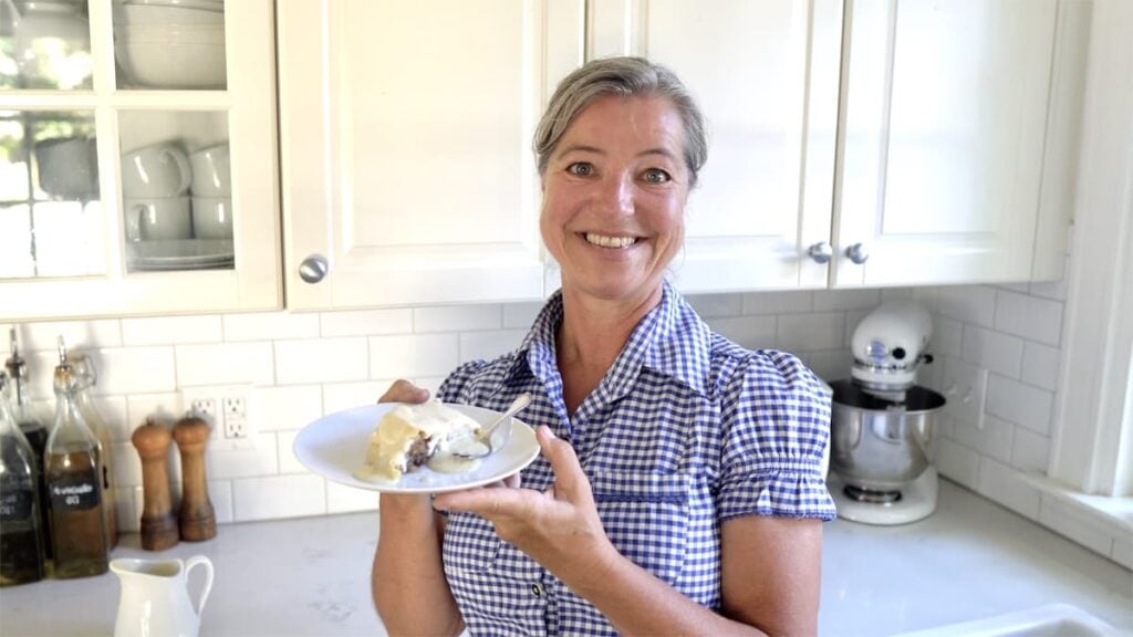 Anja in a blue checkered shirt showing a traditional German dish, available for members of The Heritage Kitchen Table